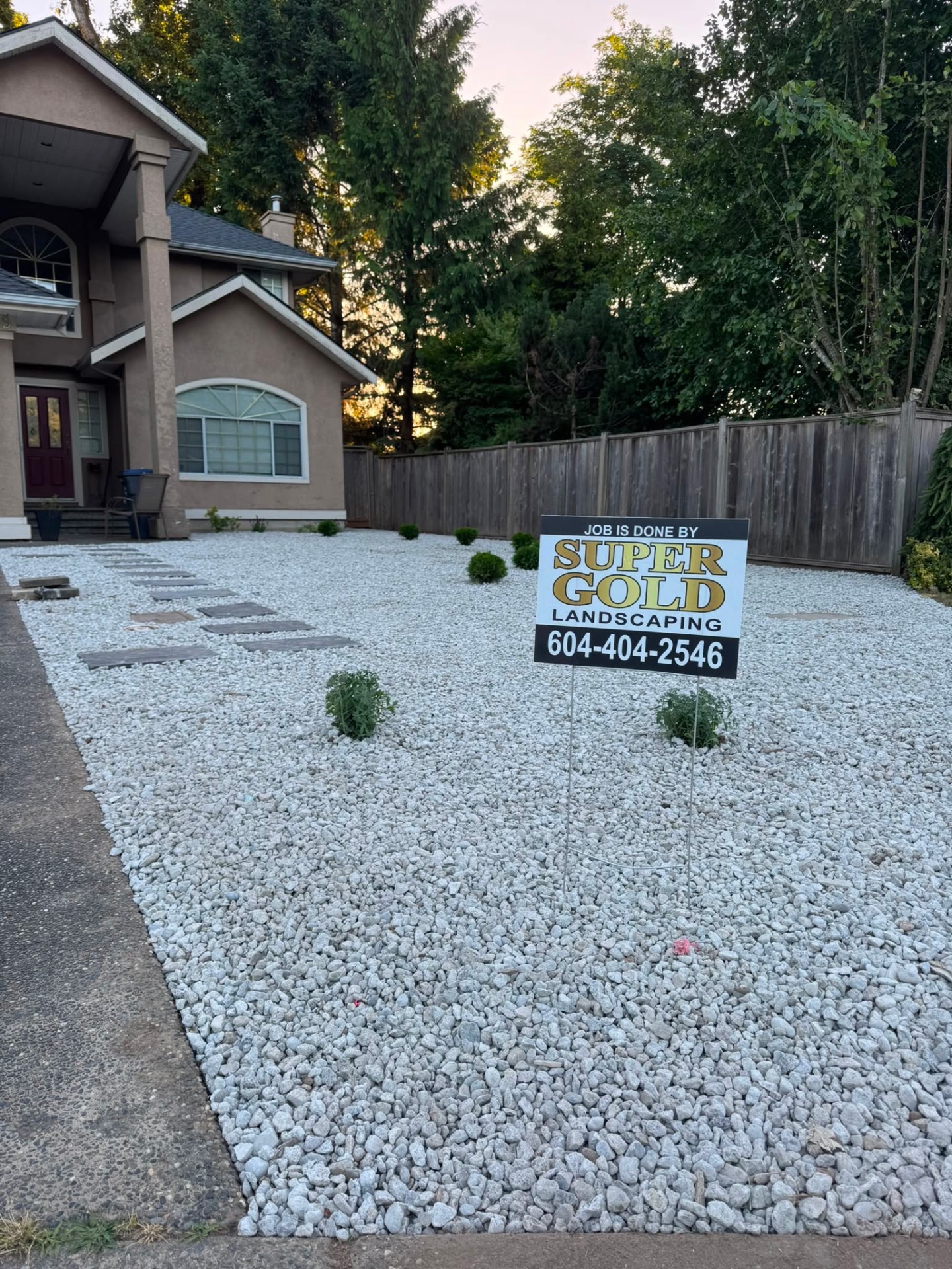 White stone rock garden with stepping stones and Super Gold Landscaping sign