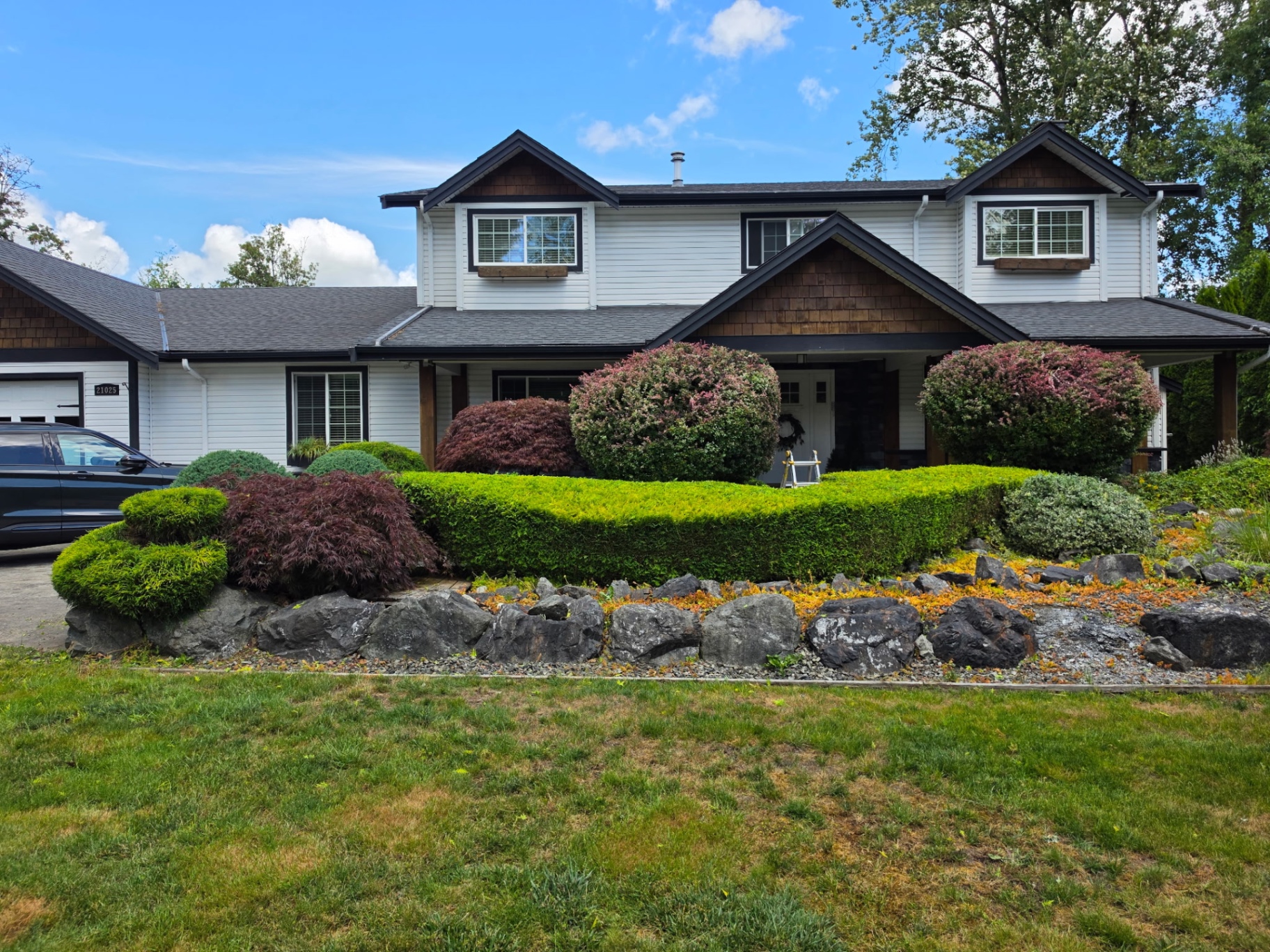 Manicured front yard with sculpted shrubs and rock garden by Super Gold